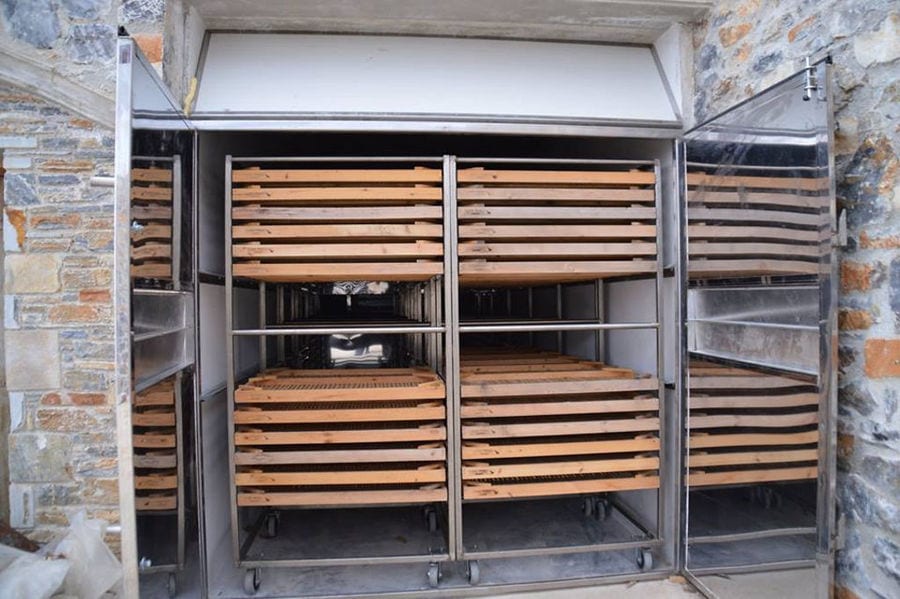 wood panels on top of each other in stainless steel food dehydrator in the wall stone at 'Gripioti Farm'